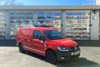 Ein rotes Transportfahrzeug mit Allradantrieb steht bei Tageslicht vor dem Gebäude der Berufsfeuerwehr Innsbruck.