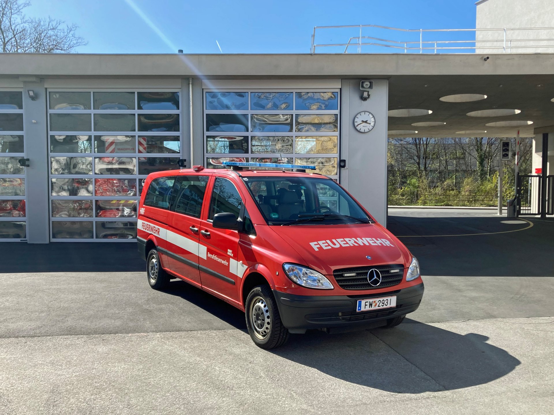 Ein rotes Höhenrettungsfahrzeug steht bei Tageslicht vor dem Gebäude der Berufsfeuerwehr Innsbruck.