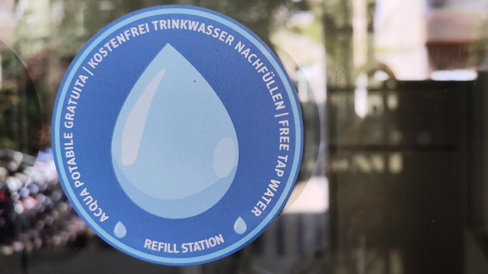 Der blaue Aufkleber mit einem Tropfen darauf zeigt an, wo Sie Ihre Wasserflasche kostenlos auffüllen können.