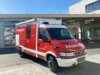 Ein rotes Taucheinsatzfahrzeug steht bei Tageslicht vor dem Gebäude der Berufsfeuerwehr Innsbruck.