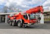 Ein rotes Kranfahrzeug steht bei Tageslicht vor dem Gebäude der Berufsfeuerwehr Innsbruck.