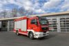 Ein rotes Gefährliche-Stoffe-Fahrzeug steht bei Tageslicht vor dem Gebäude der Berufsfeuerwehr Innsbruck.
