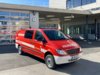 Ein rotes Wasserfahrzeug steht bei Tageslicht vor dem Gebäude der Berufsfeuerwehr Innsbruck.