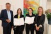 Auf dem Foto sieht man vier Personen in formeller Kleidung im Rathaus: Vizebürgermeister Georg Willi, die Hauptpreisträgerin Esther Strauß mit Urkunde in der Hand, die Förderpreisträgerin Veronika Abigail Beringer mit Urkunde in der Hand und Kulturamtsleiterin Isabelle Brandauer