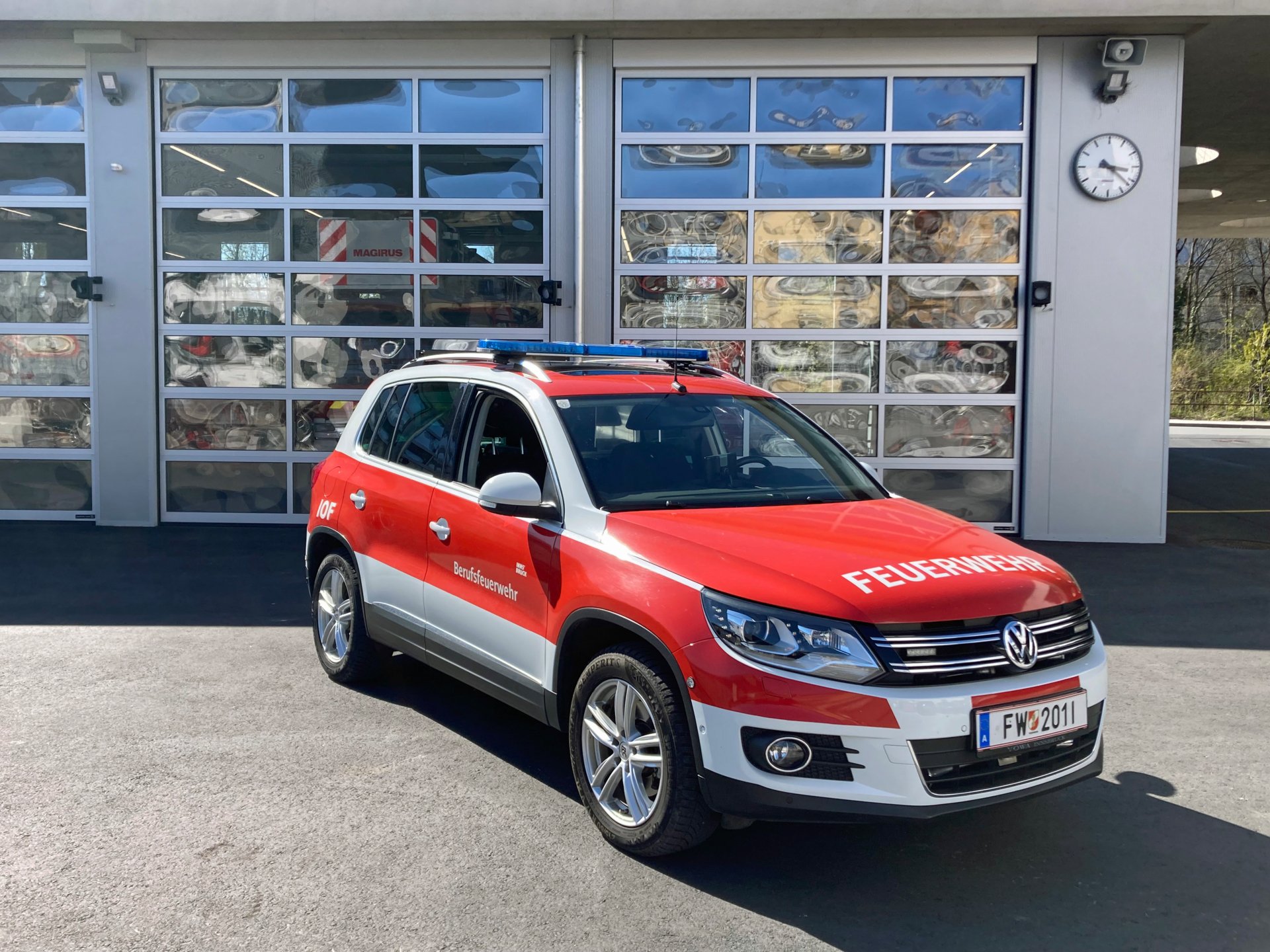 Ein rotes Inspektionsoffiziersfahrzeug mit Allradantrieb steht bei Tageslicht vor dem Gebäude der Berufsfeuerwehr Innsbruck.