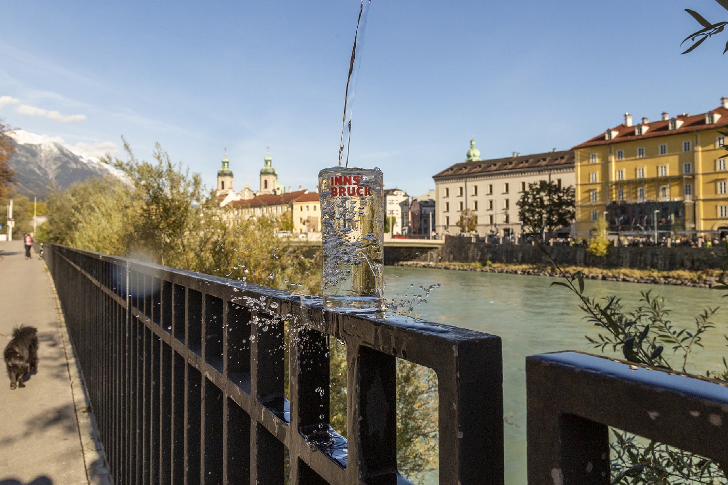 Ein Wasserglas auf einem Geländer am Inn mit Blick auf die Altstadt